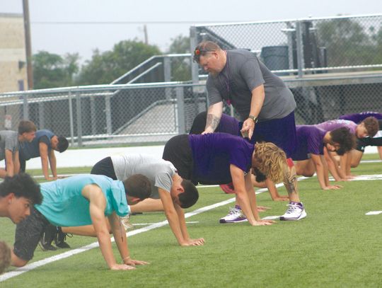 Photos by Jennifer Fierro/TexasChalk- Talk.com On first day of Marble Falls Forge '24, coaches emphasis the proper way to do each drill as illustrated by Marble Falls strength and con- ditioning coordina - tor Karl "Beef" Bielfeldt, who is helping Deagan Whitted.