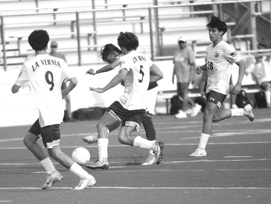 Marble Falls senior Marco Almazan tries to kick the ball into the goal as the La Vernia Bears surround him.
