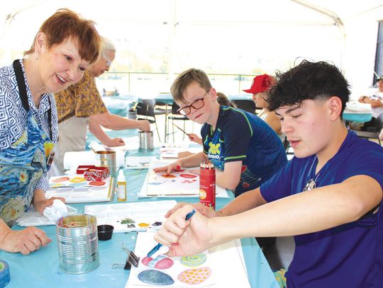 Timothy Salinas (right) concentrated on creating an artistic effect April 12 at Family Art Day, during the 2025 Paint the Town Art Festival. Volunteer Lynn Erickson and participant Zaiden Smith admired his work. Photos by Connie Swinney/The Highlander