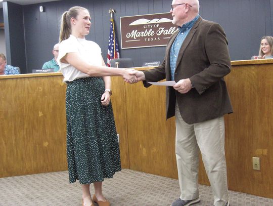 Photo by Raymond V. Whelan/The Highlander Marble Falls Mayor Dave Rhodes presents the first Daniel J. Decker Texas Travel Alliance Scholarship award to City Tourism Manager Kayla Gostnell during the Nov. 5 council meeting.