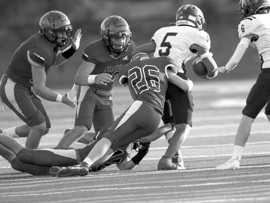 Faith Academy sophomore Price Rosamond (26) grabs ahold of Runge's Jose Mendoza by the waist while junior Beau Steele grabs his leg and senior Carter Fromberg (12) prepares to help finish the tackle during the Flames' win against the Yellow Jackets. Contributed/Stennis Shotts