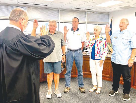 Granite Shoals Municipal Judge Frank Reilly, back to camera, swears in members of the city council at the May 13 meeting. Council members are, from left, Brian Edwards (place 1), Michael Berg (place 5), Judy Salvaggio (place 3) and Ron Munos (mayor). Edwards, Berg and Salvaggio were unoppo...