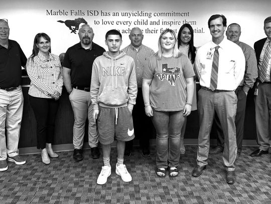 Pictured, from left, are Falls Career High School students Isaiah Bedell and Breeanna Paulk (front, center) with Falls Career High Principal Clark Fields. The Marble Falls ISD Board of Trustees is pictured in the background. Contributed/MFISD