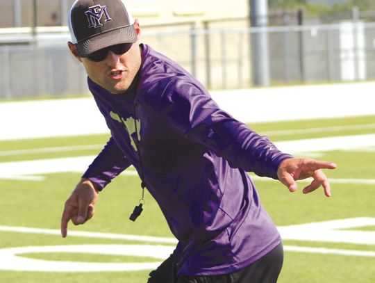 Photos by Jennifer Fierro/TexasChalkTalk.com Marble Falls defensive coordinator Ryan Craven demonstrates how he wants the defensive backs to turn as they're running backward.