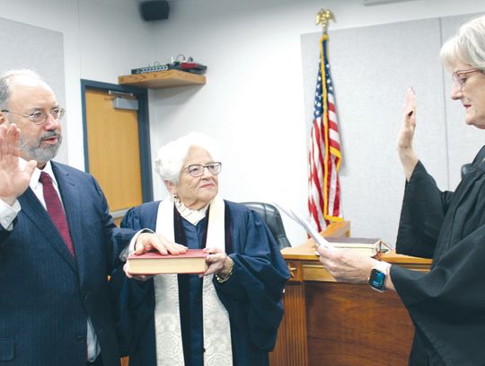 On Feb. 7, Frank Reilly, who was appointed by Burnet County commissioners to fill the precinct 4 justice of the peace spot, places his hand on the Bible held by the Rev. Sally Anderson. He was sworn in by (right) retiring Pct. 4 Justice of the Peace Debbie Bindseil. The ceremony was held i...