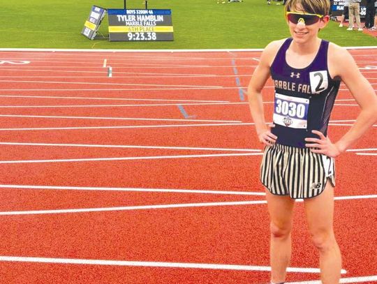 Marble Falls junior Tyler Hamblin stands in front of the scoreboard that flashes his time and finish in the 3,200 meters at the Class 4A State Track and Field Championships May 2. Contributed photo