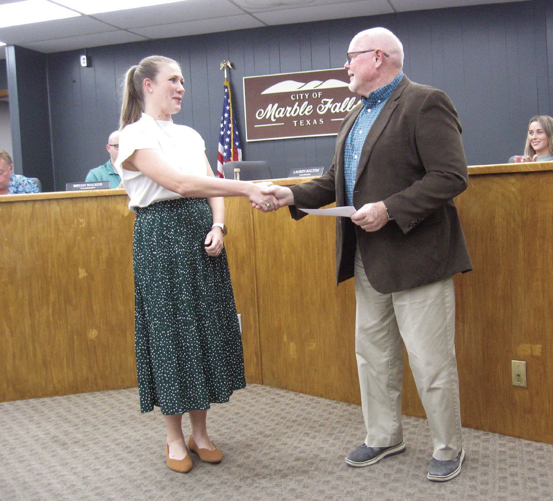 Photo by Raymond V. Whelan/The Highlander Marble Falls Mayor Dave Rhodes presents the first Daniel J. Decker Texas Travel Alliance Scholarship award to City Tourism Manager Kayla Gostnell during the Nov. 5 council meeting.