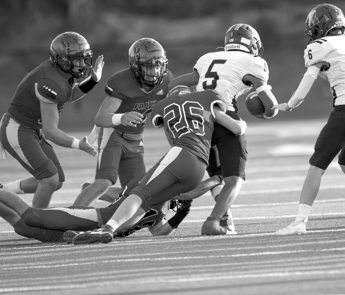 Faith Academy sophomore Price Rosamond (26) grabs ahold of Runge's Jose Mendoza by the waist while junior Beau Steele grabs his leg and senior Carter Fromberg (12) prepares to help finish the tackle during the Flames' win against the Yellow Jackets. Contributed/Stennis Shotts