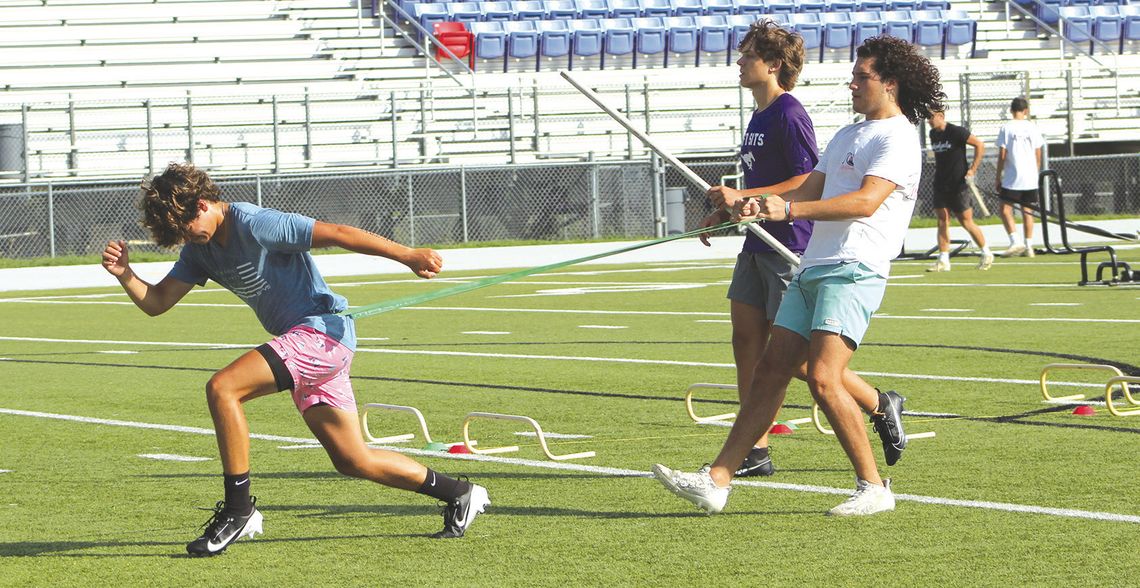 Paolo Garza holds bands that are around Noah Luckie's waist as he runs while Landon Griffith completes running over tiny obstacles while holding a pipe over his head. Photos by Jennifer Fierro/TexasChalkTalk.com