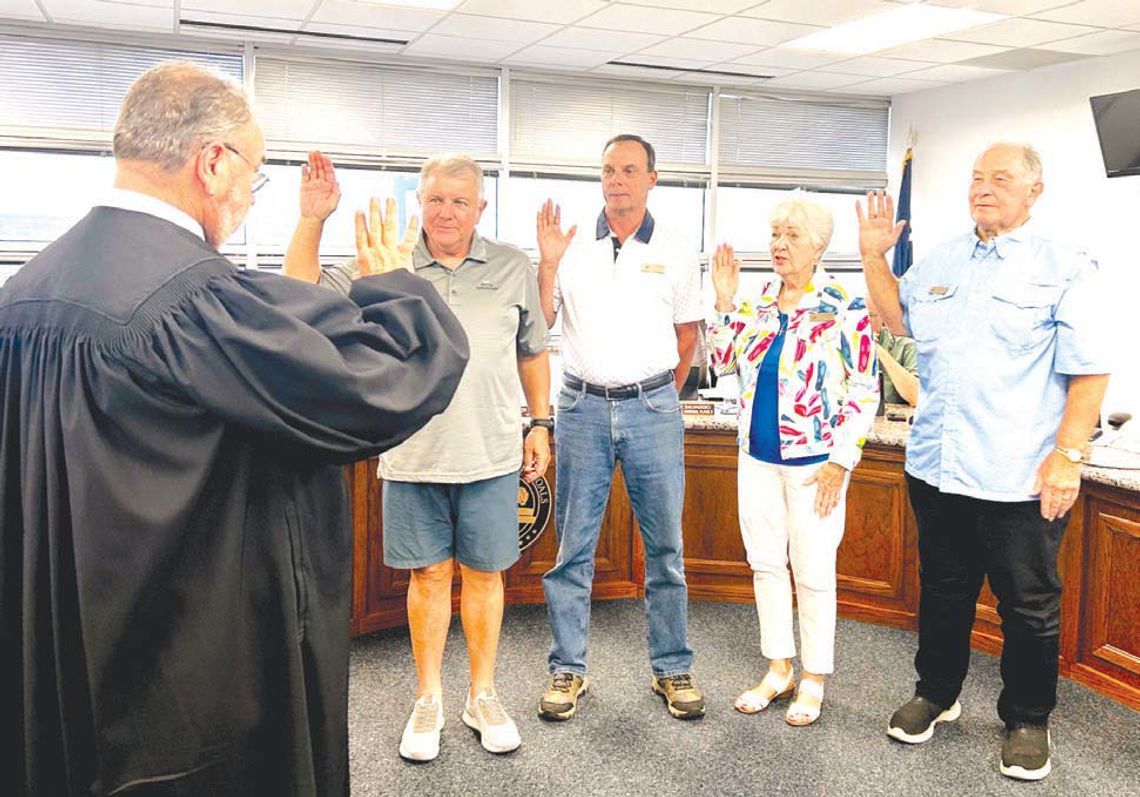 Granite Shoals Municipal Judge Frank Reilly, back to camera, swears in members of the city council at the May 13 meeting. Council members are, from left, Brian Edwards (place 1), Michael Berg (place 5), Judy Salvaggio (place 3) and Ron Munos (mayor). Edwards, Berg and Salvaggio were unoppo...