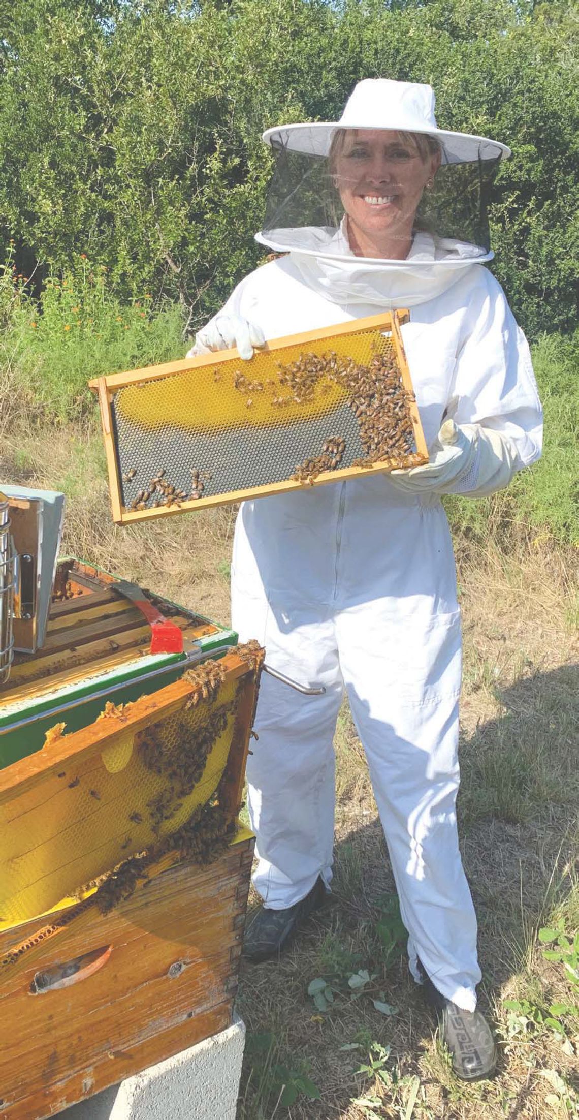 All the Buzz Jessica Murray, assistant librarian at the Oakalla Library, is pictured here at the hive of bees on the grounds of the venue. Contributed/ Jesse Pratt