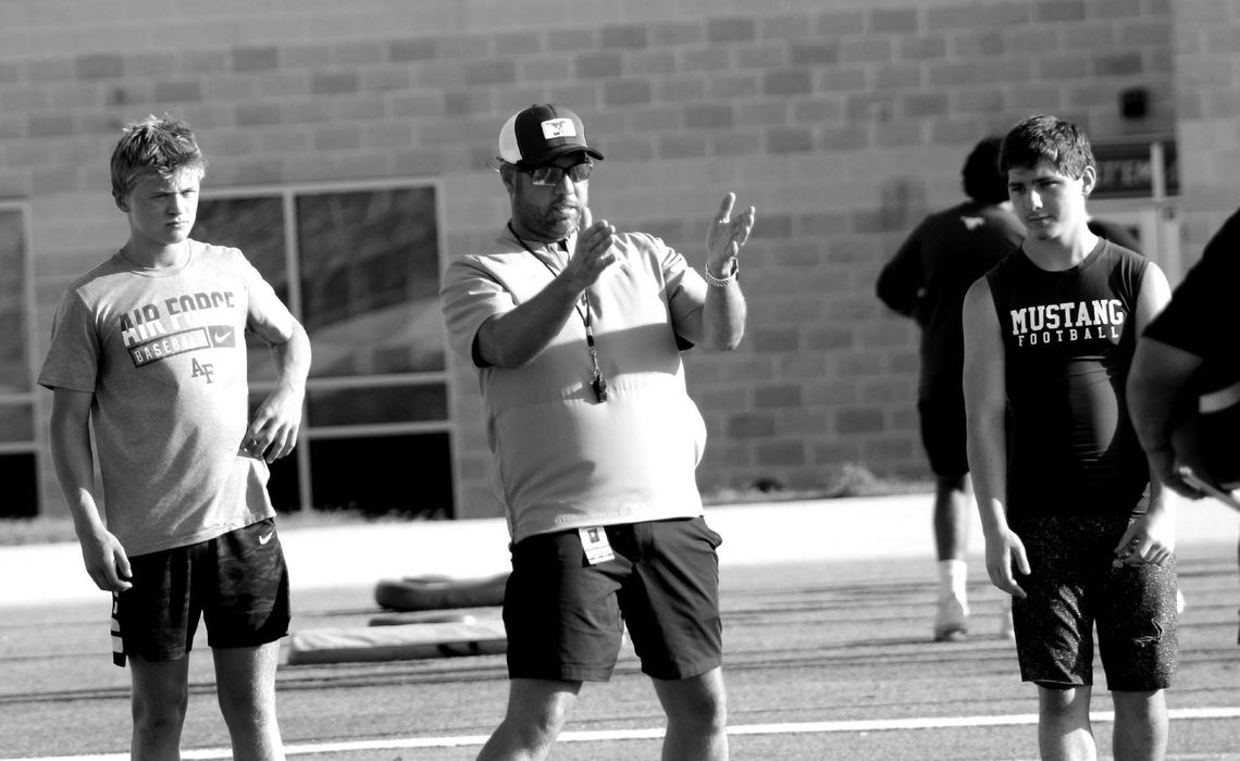 During last year's football camp, Mustangs head coach Keri Timmerman, who also serves as the program's quarterbacks coach, worked closely with Crawford Mattox (left) and Hayden Liscum. This year, Mattox is vying for the starting quarterback position on the varsity.