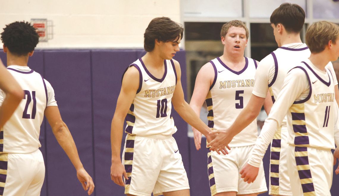 Senior forward Garen Jones (10) is congratulated by senior forward Reed Lewis (2) and senior forward Noah Lyon (5) after getting fouled while scoring. Sophomore guard Beckett Berkman (11) heads to the mid court to as the others get lined up for the free throw.