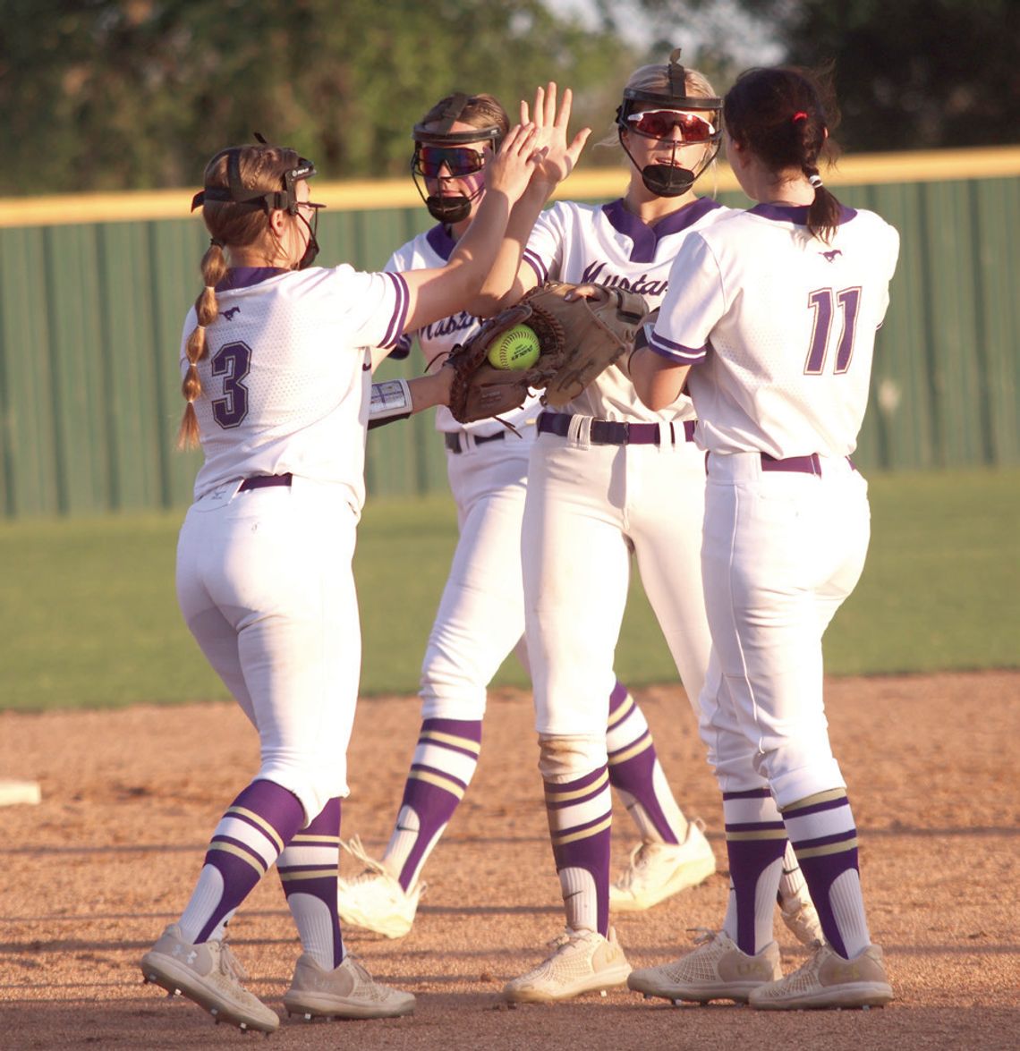 Freshman pitcher Brooklyn Damico (3) congratulates senior second baseman Kylie Roberts for catching a line drive for an out as senior first baseman Sophia Biagii (11) and freshman shortstop Callie Phillips join them.